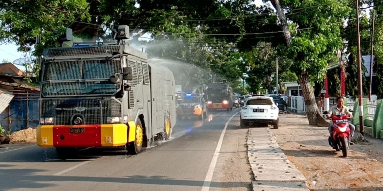 Petugas kepolisian menyemprotkan cairan disinfektan, di jalan raya Kota Palembang (Foto-Dedy) Sumber : Koransn.com