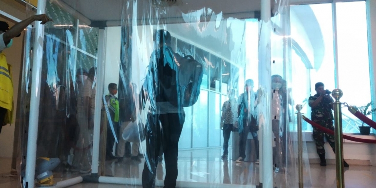 Salah seorang penumpang melakukan penyemprotaN desinfektan di Bandara Sis al Jufri. FOTO: DOK.PRIBADI