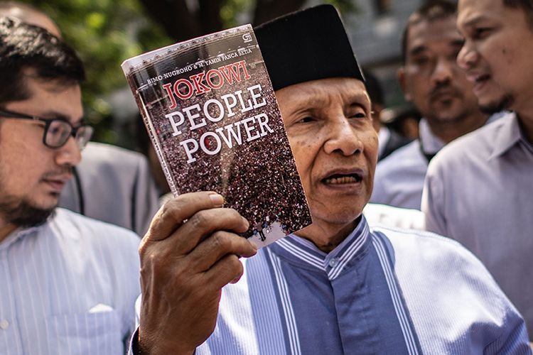 Amien Rais (tengah) menunjukkan buku berjudul Jokowi People Power. (Foto: ANTARA FOTO/APRILLIO AKBAR)