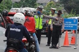 Polisi menghalau pengendara tak bermasker yang hendak masuk ke Jakarta selama PSBB. Foto: KOMPAS.com/Antara