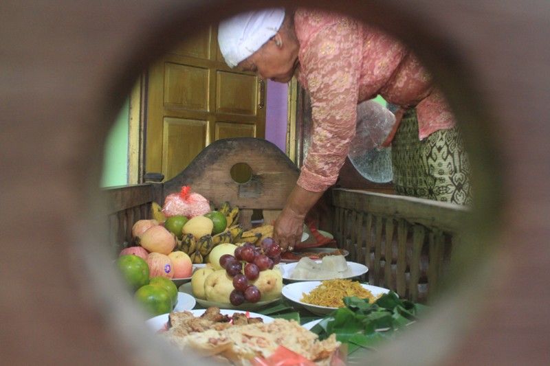 Simbah menata makanan di dalam jodang saat tradisi sadranan (Foto: Darma Legi)