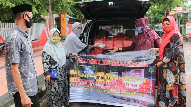 Estha Karim (kanan) bersama sesama Alumni Bersaudara membagikan paket takjil (20/05/20). | dokpri