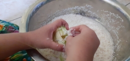 Mengisi sarung ketupat dengan beras (dokpri)