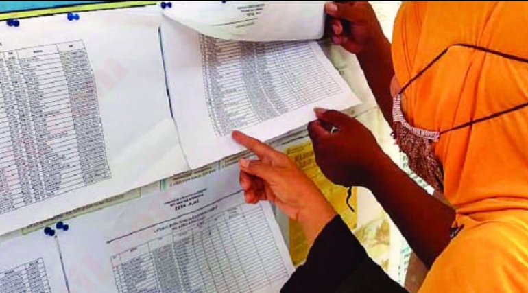 Warga mengecek namanya saat melihat pengumuman penerimaan Bantuan Sosial. (Foto. Radar Banyuwangi.)