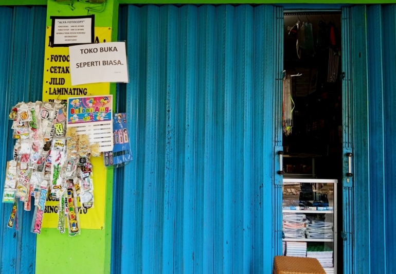 Gara-gara pandemi, toko ATK di Kabupaten Bogor ini membuka tokonya dengan cara menyisakan sedikit celah di pintu (foto: widikurniawan)