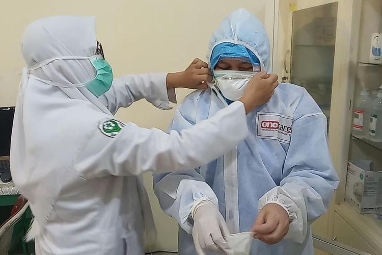 Nining (45), salah seorang perawat khusus covid-19 RSUD Soekardjo Tasikmalaya sedang memakai hazmat saat hendak merawat pasien corona di ruang isolasi, Rabu (22/4/2020).(KOMPAS.COM/IRWAN NUGRAHA) 