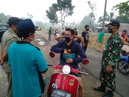 Pemerintah Desa Pepedan memberhentikan pengendara motor yang tidak menggunakan masker/Foto: Kecamatan Karangmoncol