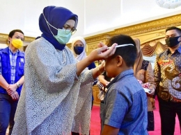Ketua PKK SulSel memakaikan masker kepada salah seorang anak penerima bantuan (01/06/20).. | Dokpri
