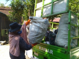 Roro Hendarti mengangkut sampah dari warga ke atas gerobak bermotor/Foto: Lilian Kiki Triwulan