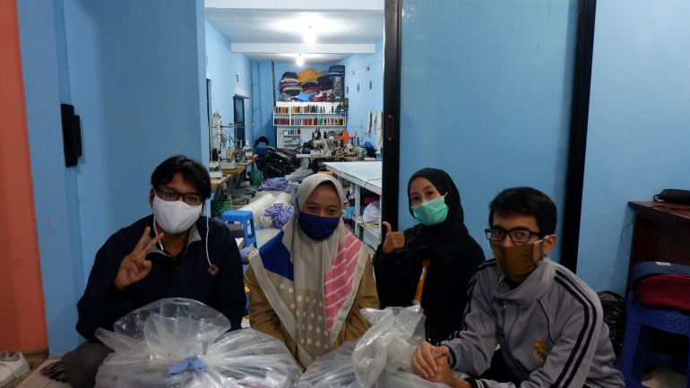 Sejumlah mahasiswa KKN UM berfoto dengan seribu masker yang siap diberikan ke perangkat desa Senggreng