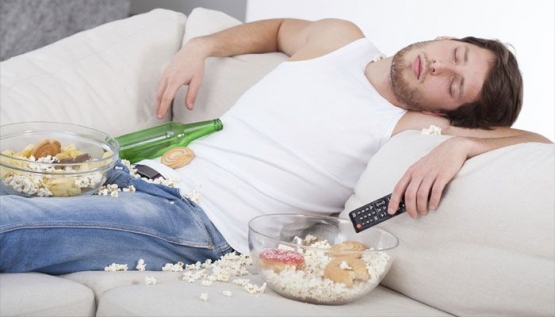 Ilustrasi orang malas yang ditandai dengan tidur di sofa dengan Tv masih menyala dan makanan yang berantakan (Sumber: infobekasi.co)