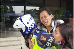 Masyarakat yang terkena serangan jantung di Halte TransJakarta, Jumat (14/2/2020) digendong oleh petugas kepolisian menuju RS Harapan Kita, Jakarta.(TMC Polda Metro Jaya) via Kompas.com