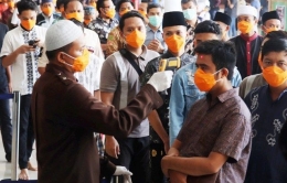 jamaah shalat jumat diperiksa suhu tubuhnya dan diwajibkan untuk mengenakan masker sebelum masuk ke dalam masjid | foto: jawapos.com