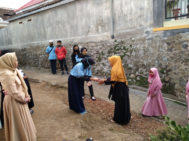 Pemberian handsanitizer kepada jamaah tahlil