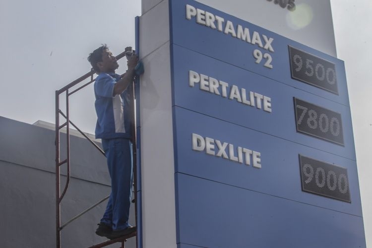 Pekerja membersihkan papan harga Bahan Bakar Minyak (BBM) di tempat pengisian BBM Pertamina, Bogor, Jawa Barat, Senin (2/7/2018).(ANTARA FOTO/MUHAMMAD ADIMAJA)