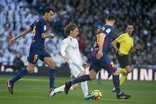 Gelandang serang Real Madrid, Luca Modric diapit oleh 2 pemain Barcelona.(foto La Liga.com)