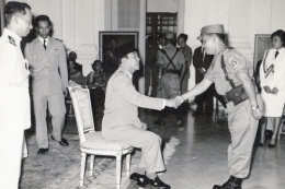 Bekas Komandan Detasemen Kawal Presiden Soekarno, Mangil Martowidjojo, ketika menyalami Presiden Soekarno yang genap berusia enam puluh tahun pada tahun 1961. (sumber: Ipphos via kompas.com)