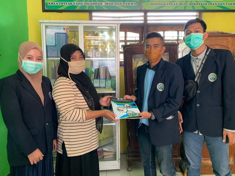 Dokumentasi penyerahan Buku Edukasi Pengolahan Sampah Berbasis 3R (Reduce, Reuse, Recycle) kepada kepala TK Dharmawanita, Ibu Nurilah