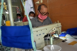 Seorang penjahit tengah mengerjakan orderan masker kain. | foto: Tommi Andryandy/Pikiran Rakyat