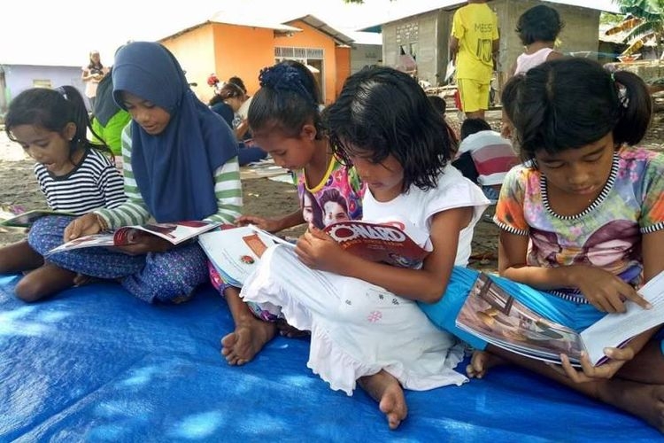 Beberapa orang anak tampak serius membaca buku kesukaannya saat Rumah Baca Barakate, Komunitas Hikayat Tanah Hitu. Foto diambil pada Minggu, (30/5/2017).| Sumber: KOMPAS.com/Rahmat Rahman Patty