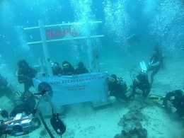 Foto by Dewi A (MORA mmembentangkan spanduk ucapan hari kelautan Nasional di lokasi dive Susi Bomber