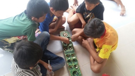 sekelompok anak laki-laki bermain congklak (sumber gambar : https://wartakota.tribunnews.com)