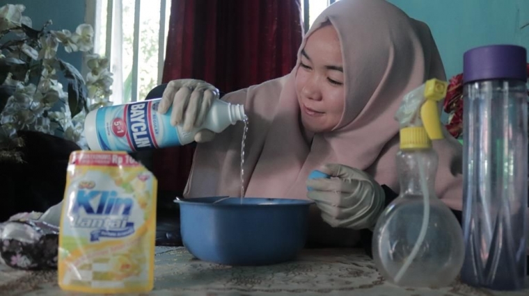 Salah satu Mahasiswa KKN Mandiri 91 UNIB memperaktikan pembuatan disinfektan yang mudah sendiri di rumah dengan bahan-bahan yang mudah didapatkan, Desa Nakau (26/6).
