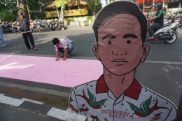 Warga membubuhkan tanda tangan dukungan terhadap putra sulung Presiden Jokowi, Gibran Rakabuming Raka maju Pilkada Solo 2020 di Jalan Bhayangkara Solo, Jawa Tengah, Minggu (3/11/2019). (Foto: KOMPAS.com/LABIB ZAMANI)