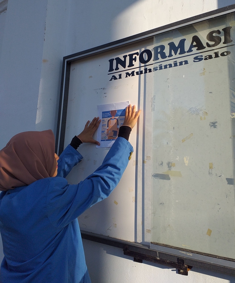 Proses pemasangan poster di lingkungan desa salo. Dok. pribadi.