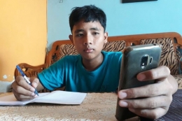 Seorang siswa belajar online menggunakan ponsel (Kompas.id)