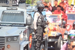 Seorang petugas kepolisian berdiri di kendaraan dinas mengawal para kandidat Gubernur Malut, (12/6/2018) Dokpri.