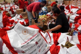 Pekerja mengemas Bantuan Sosial di Gudang Food Station, Cipinang, Jakarta (22/4). Sumber: https://money.kompas.com/read/2020/04/28/182000426/sederet-b
