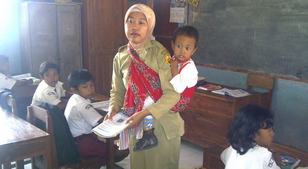 Retno menggendong Fakhri saat mengajar (foto: Sindo TV/Rustaman Nusantara) via Okezone.