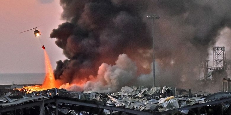  Kompas.com: Sebuah helikopter berusaha memadamkan api dalam ledakan yang terjadi di pelabuhan Beirut, ibu kota Lebanon, pada 4 Agustus 2020.(STR via AFP)