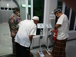 Gambar 2. Warga langsung mencoba Touchless Hand Sanitizer Pijak selepas shalat isya berjamaah di masjid (sumber: Galeri Penulis)