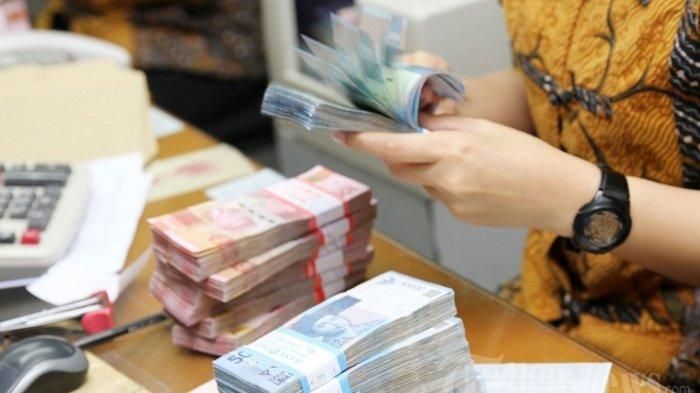 Ilustrasi seorang karyawan menghitung mata uang dalam bentuk pecahan Rp 50.000 dan pecahan Rp 100.000. Hari ini, pemerintah akan membagikan gaji ke-13 untuk pegawai negeri sipil (PNS) TNI Polri. | Foto: kaltim.tribunnews.com