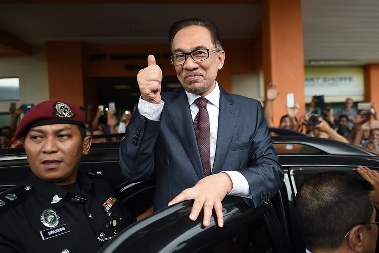 Mantan pemimpin oposisi Malaysia Anwar Ibrahim mengacungkan ibu jari ke arah para pendukungnya saat meninggalkan RS Cheras, Kuala Lumpur, Rabu (16/5/2018). (AFP/MOHD RASFAN)