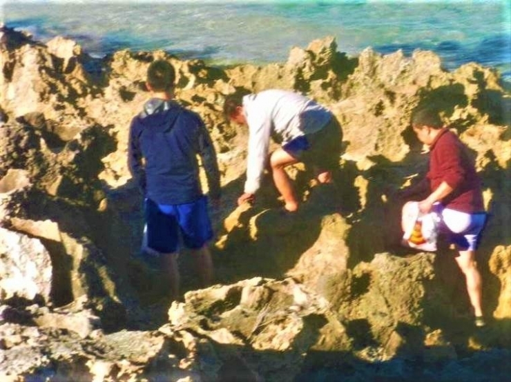 ket.foto: merangkak di bukit karang yang tajam, Saya  berbaju putih dan dikawal putra kami berbaju merah dan cucu kami berbaju biru/dok pri