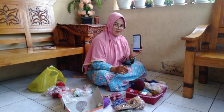 Siti Badriyah (38), Perajut tas, sepatu, dan beberapa perlengkapan lainnya sedang berfoto bersama aplikasi UMKMGebugan. Dok. pribadi.