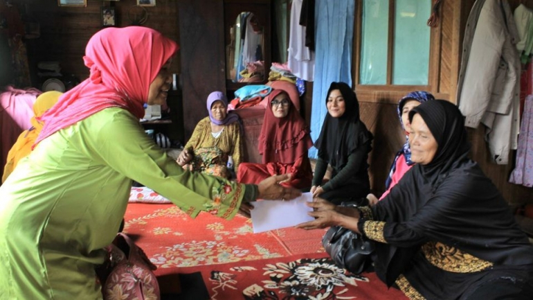 Dra. Zusneli Zubir, M.Hum., Ketua HWK Sumbar saat serahkan bantuan dari HWK Sumbar dan STO, diterima oleh Yur, kakak kandung Kurnia. (Dok. Istimewa)