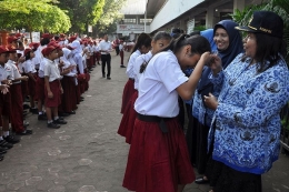 Sejumlah siswa menyalami guru mereka seusai mengikuti upacara di Sekolah Dasar Negeri 060813 Medan, Sumatera Utara, Senin (25/11/2019). Menyalami guru oleh para siswa tersebut dalam rangka memperingati Hari Guru yang serentak dilaksanakan di seluruh Indonesia.(ANTARA FOTO/SEPTIANDA PERDANA)