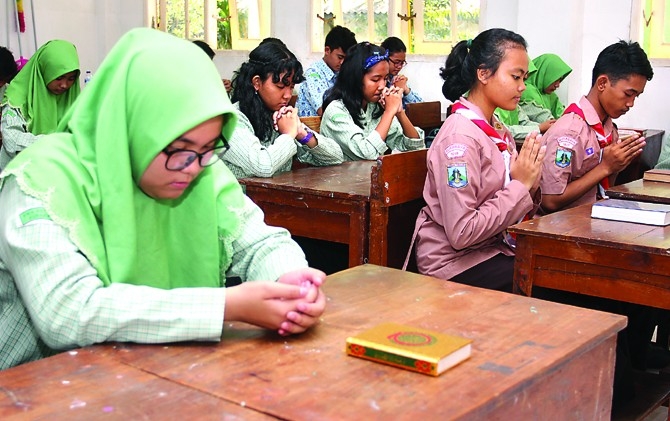 Para murid SMAN 8 Surabaya berdoa pagi menjelang pelajaran dimulai. Suasana religius memperkuat toleransi di antara mereka. (Allex Qomarullah/Jawa Pos/JawaPos.com)