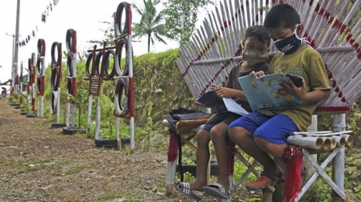 Dua murid SD belajar di ruang terbuka di pinggir jalan yang ada signal kuat di pelosok Banten. Foto : ANTARA diunggah dari BBC.com