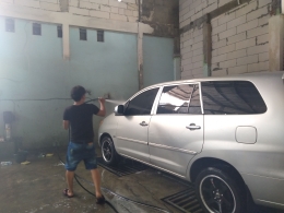 Seorang karyawan sedang mencuci mobil pelanggan / dokumen pribadi 