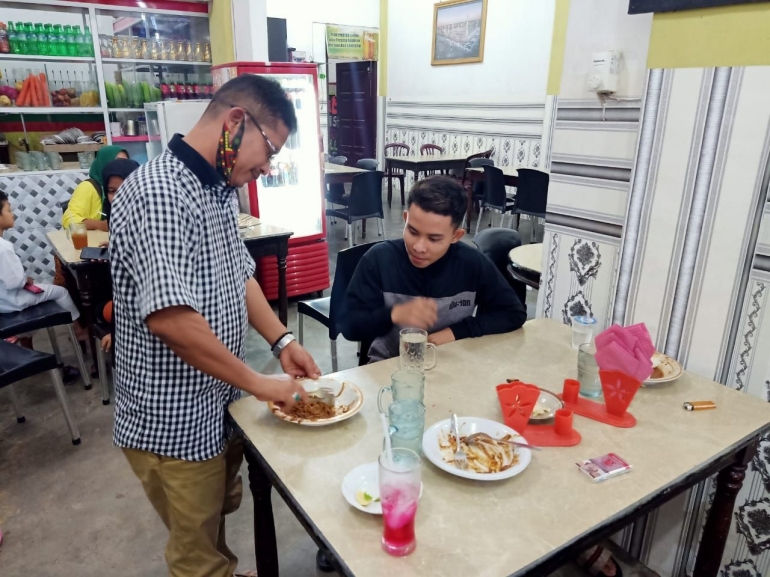 Photo: Maimul mahdi melayani pengunjung warung miliknya (dok: agus mandor)