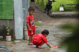 Dua anak tengah bermain air hujan di Salatiga (Dokpri)