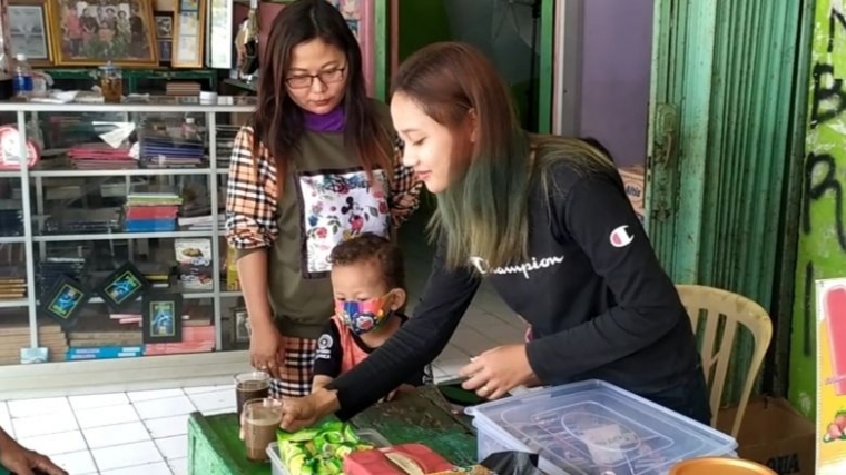 Melani saat melayani penikmat kopi yang sebagian adalah para sopir angkot diterminal. (FOTO:Cokie)