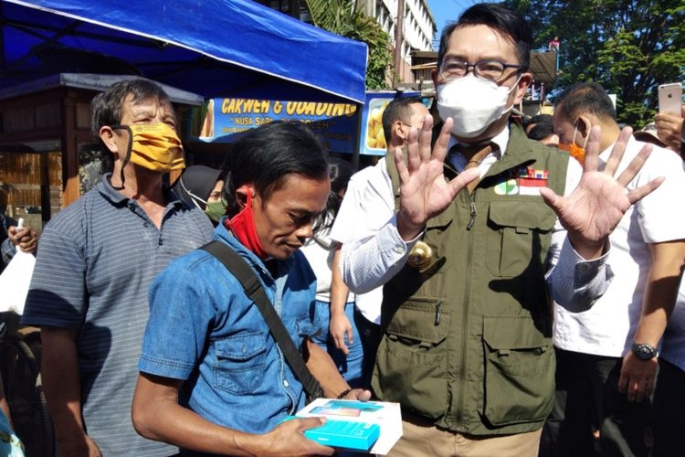 Gubernur Jawa Barat Ridwan Kamil saat memberikan hadiah berupa gawai kepada Ade Londok setelah viral mempromosikan Odading Mang Oleh di Jalan Baranangsiang, Kota Bandung, Rabu (16/9/2020).(KOMPAS.COM/DENDI RAMDHANI)