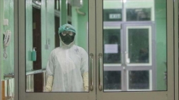 Petugas Rumah Sakit Berjalan Di Dalam Ruangan Isolasi Khusus Untuk Wabah Virus Corona Di Rumah Sakit Umum Daerah Zainal Abidin, Aceh. (Serambi/Hendri)