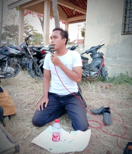 Endi Widodo saat jadi reporter KPPMG Cup di lapangan sepakbola Desa Grinting